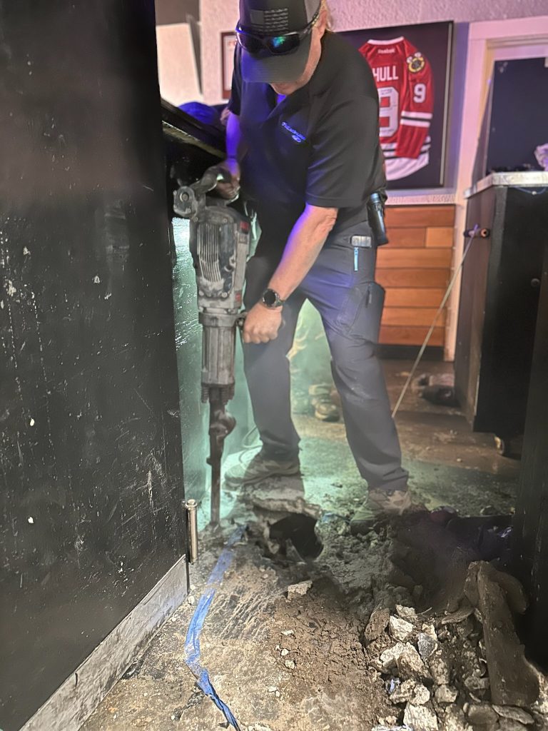 Jeremy with I Find Leaks jackhammering a floor to expose a slab leak