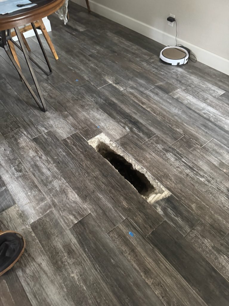 Only one wood plank tile removed to expose a slab leak in Largo Florida.