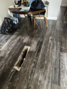 Only one wood plank tile removed to expose a slab leak in Largo Florida.