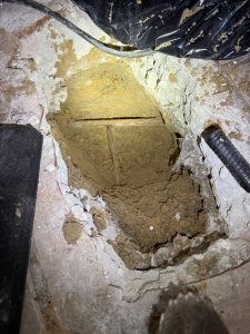 An exposed copper slab leak spraying water on a Dunedin water leak detection job.