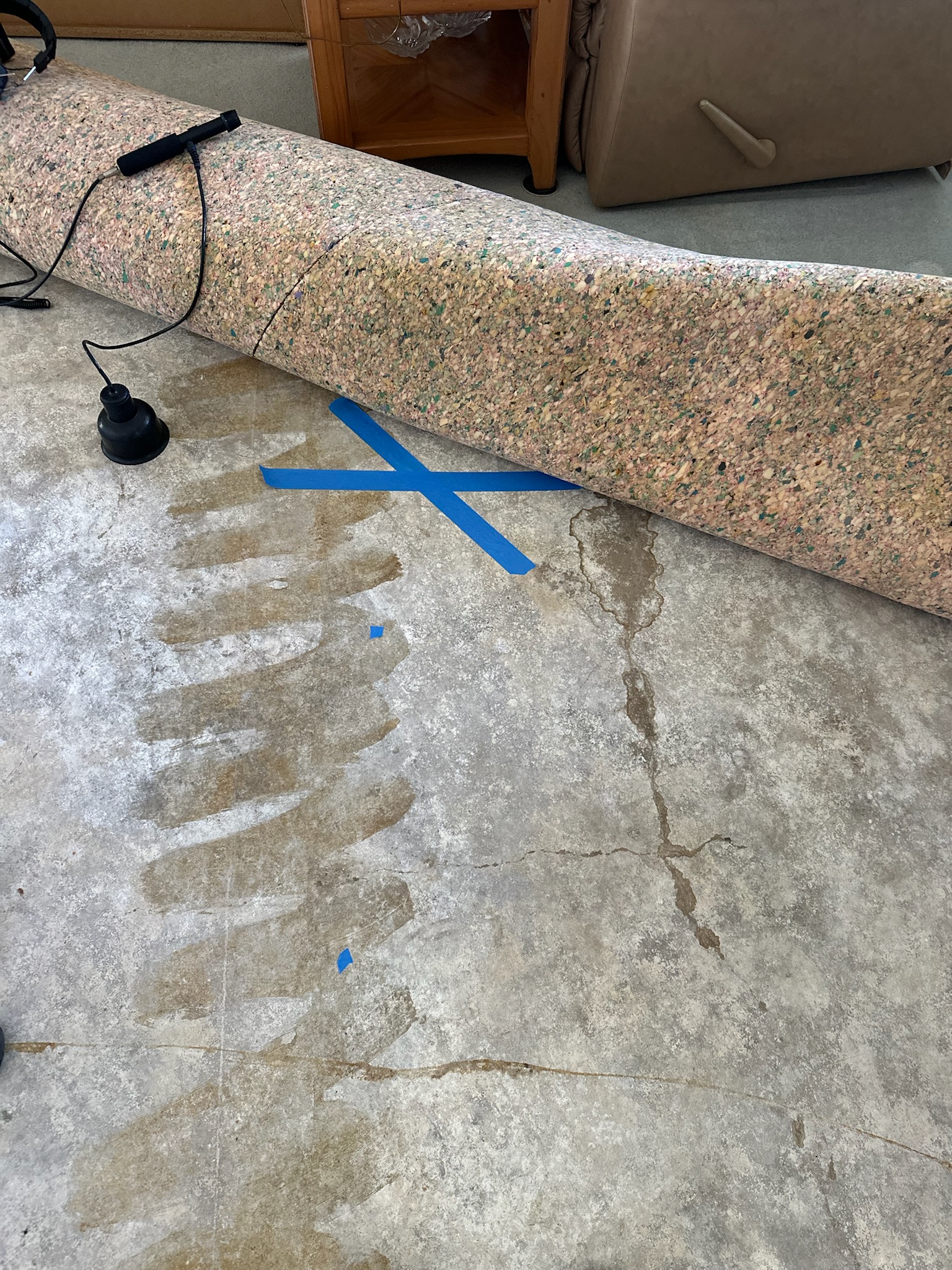 A blue X marked on the concrete in a home in Seminole depicting where a slab leak is located. 