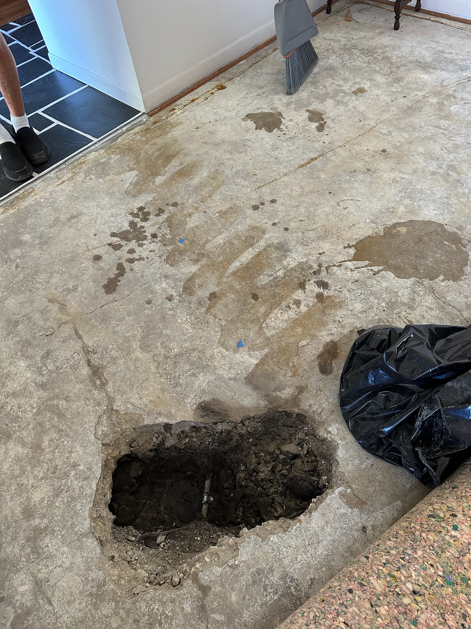 A hole in a slab floor exposing a leak causing a high water bill in Seminole Florida.