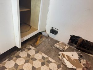 A laundry room in St Petersburg where a plumber cut holes in the wall and left a huge mess trying to find a hidden water leak.