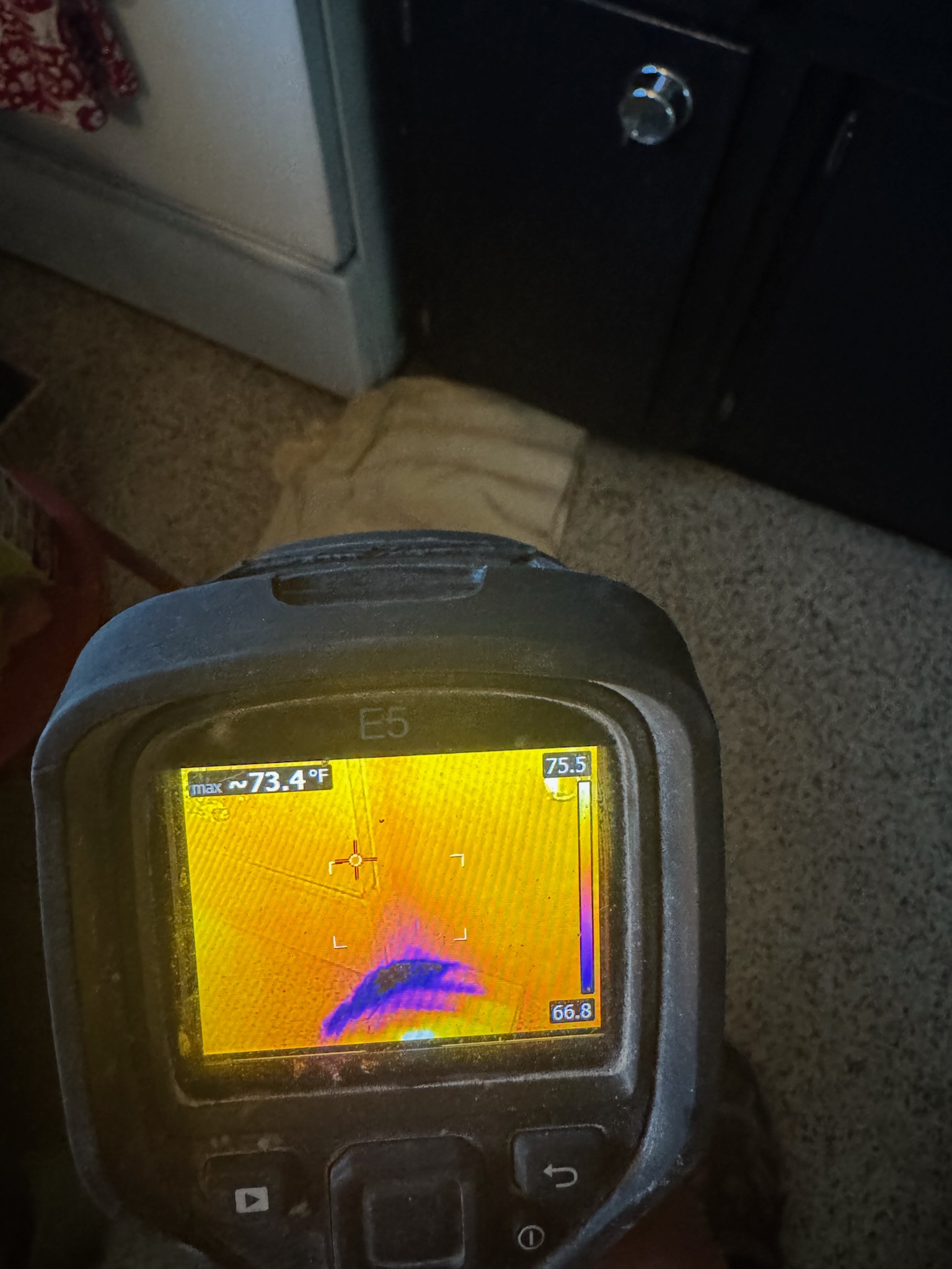 A Flir infrared camera inspecting under kitchen cabinets for a water leak in St Petersburg.