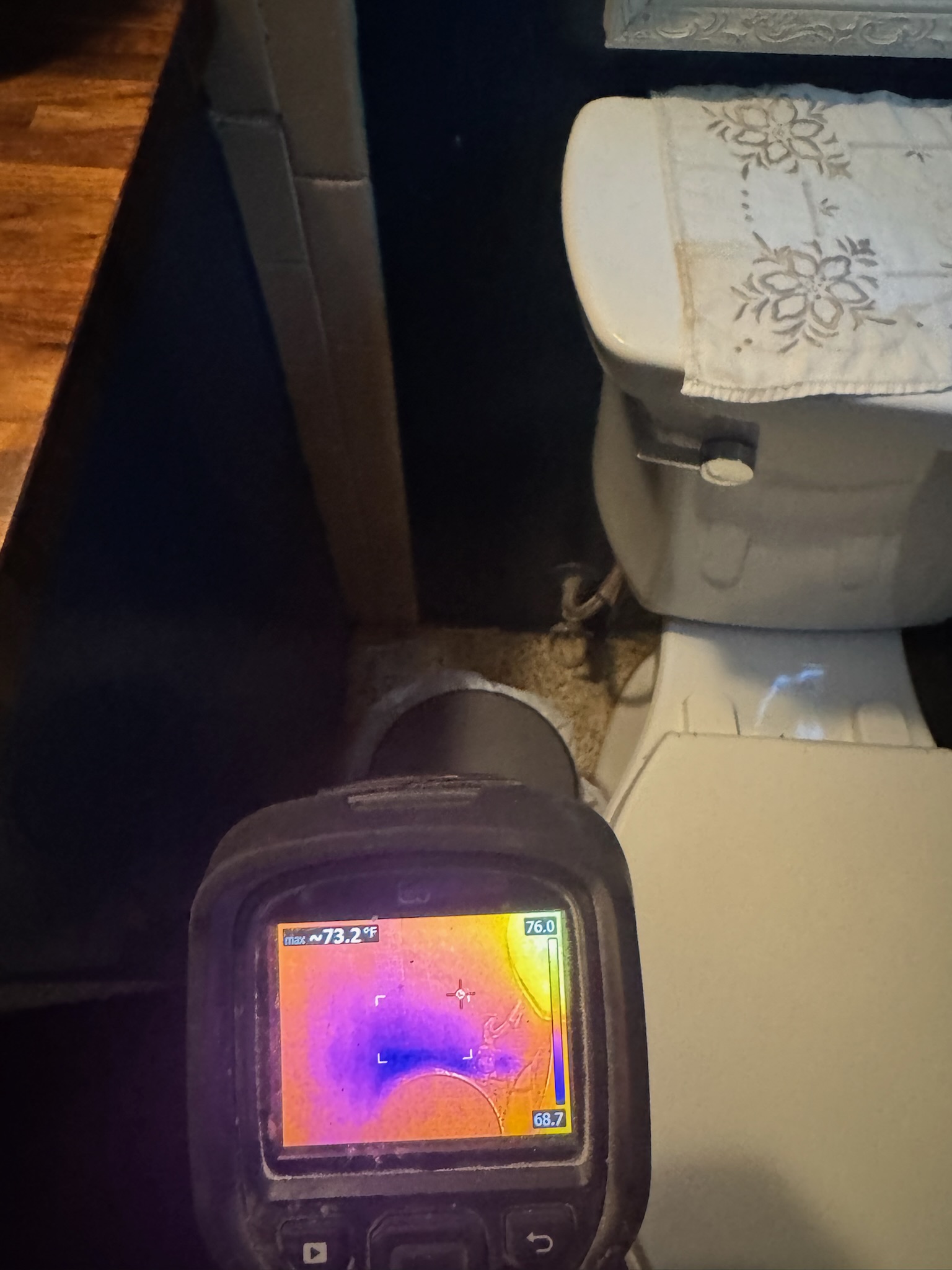 A Flir infrared camera inspecting for water damage behind a toilet in St Petersburg.