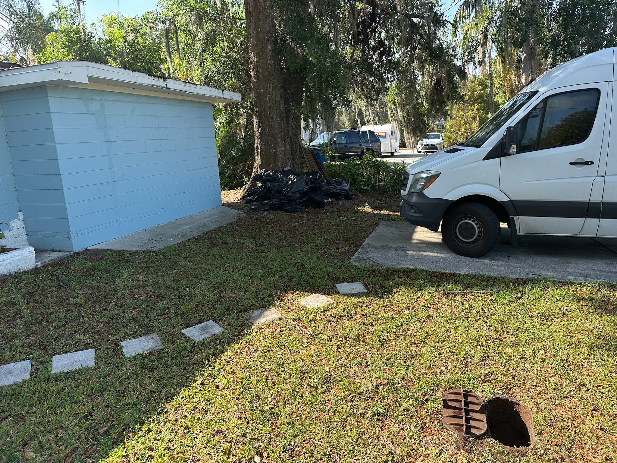 Leak detection van parked in Clearwater driveway near a blue block home.