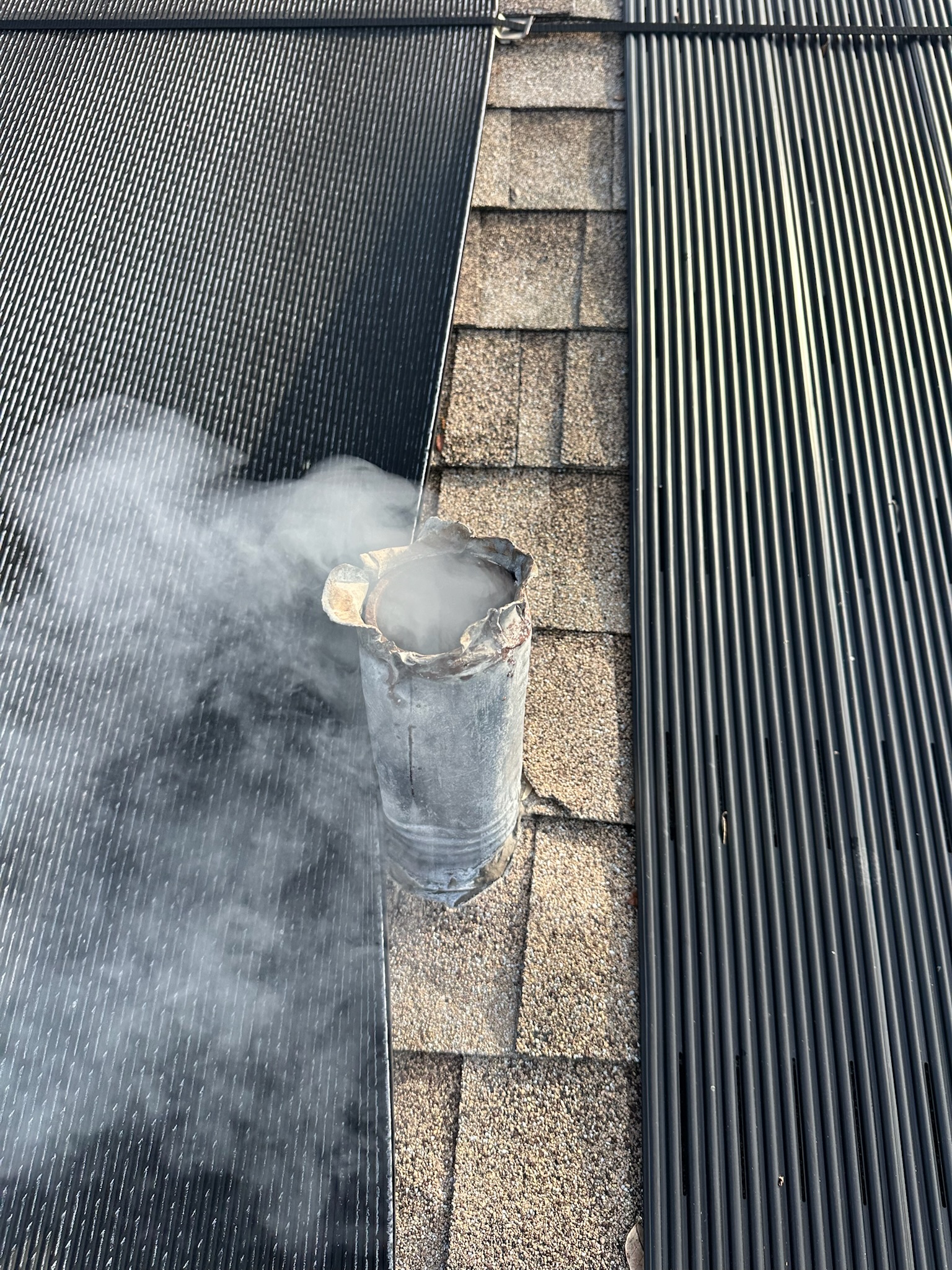 Close-up of sewer vent stack with heavy smoke discharge during Clearwater odor test.