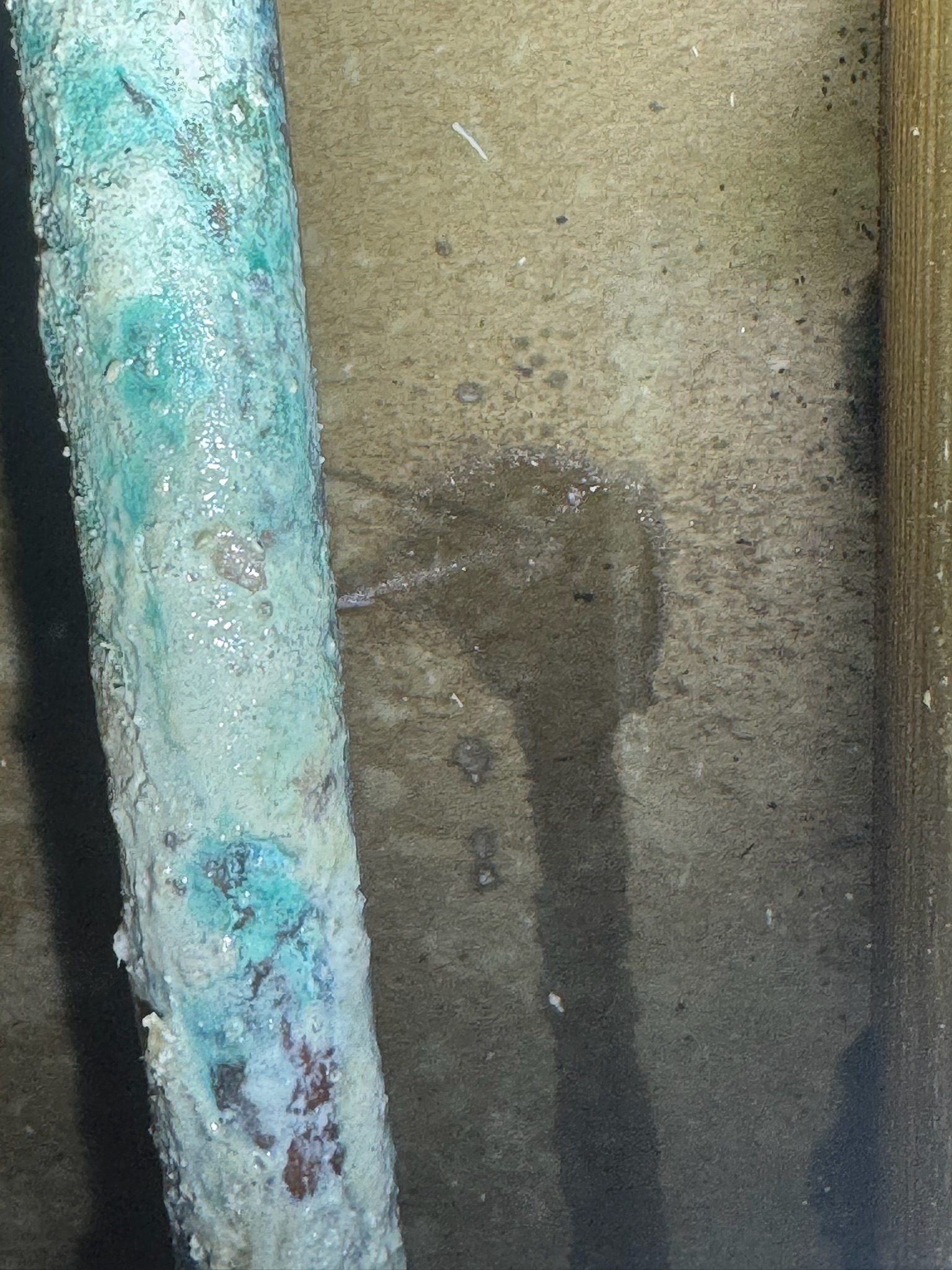 Close-up of pinhole leak on corroded copper pipe spraying water in Madeira Beach home