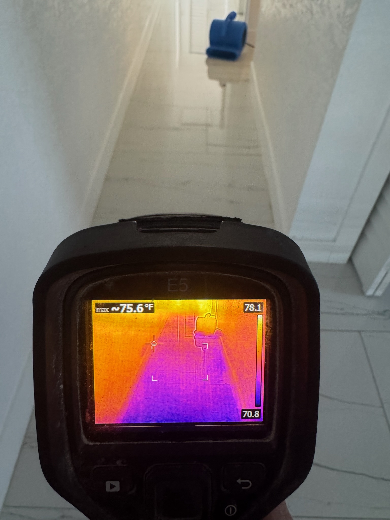 Jeremy using FLIR infrared camera to inspect moisture levels in Madeira Beach home hallway