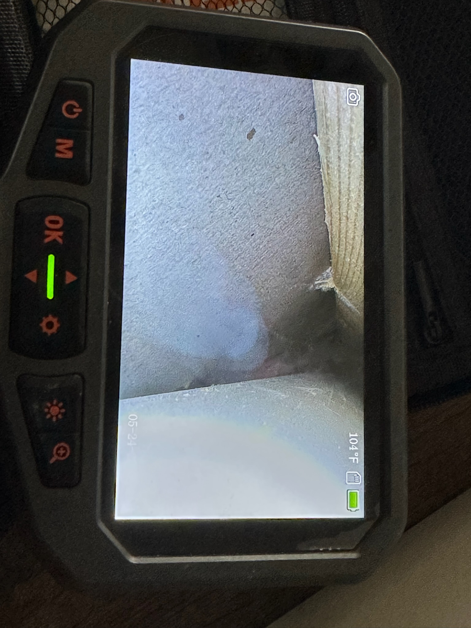 Palm Harbor technician using inspection camera to locate sewer odor source inside wall before cutting.