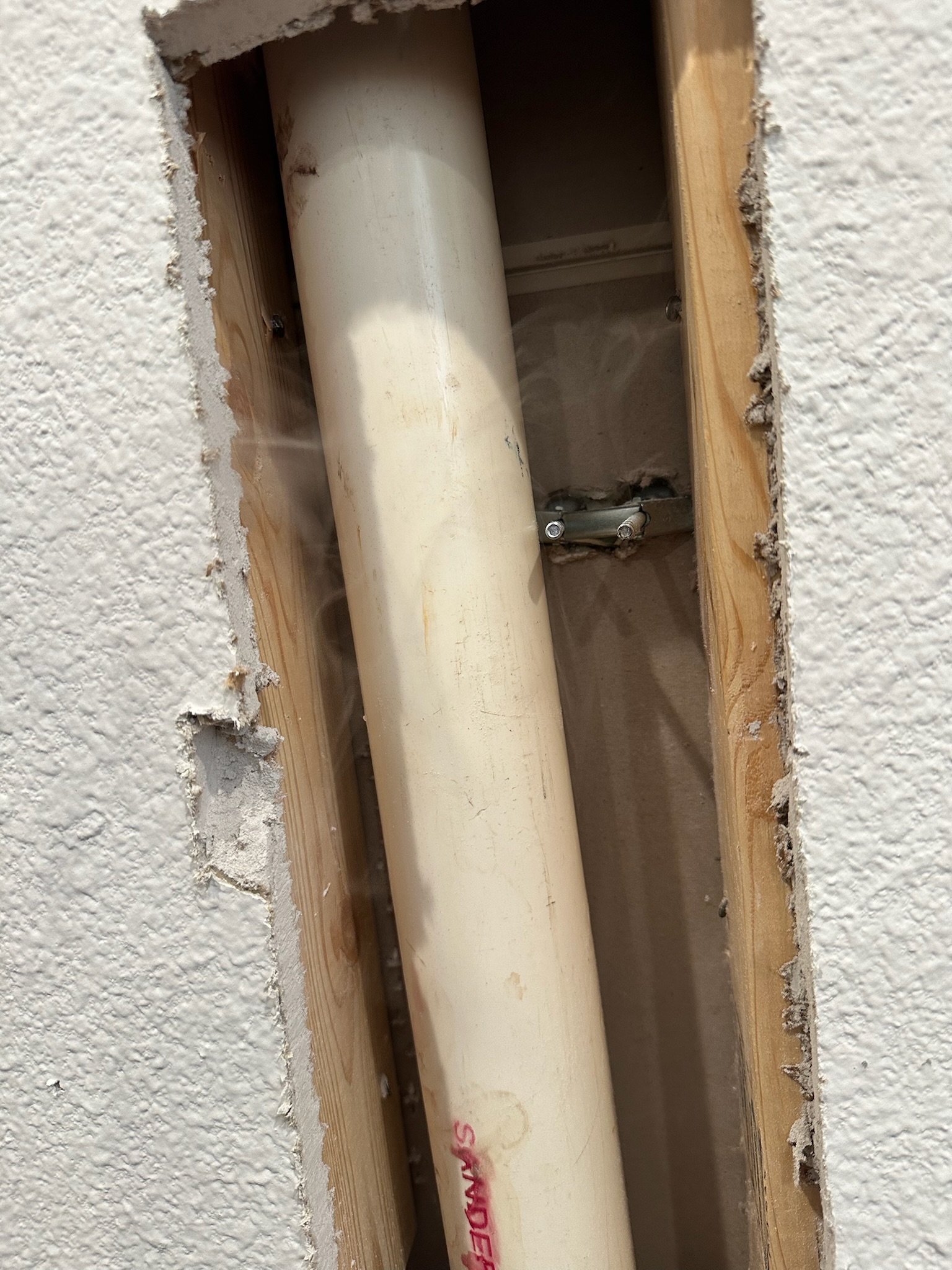 Single hole in wall reveals a sewer pipe punctured by vanity installation in Palm Harbor office.