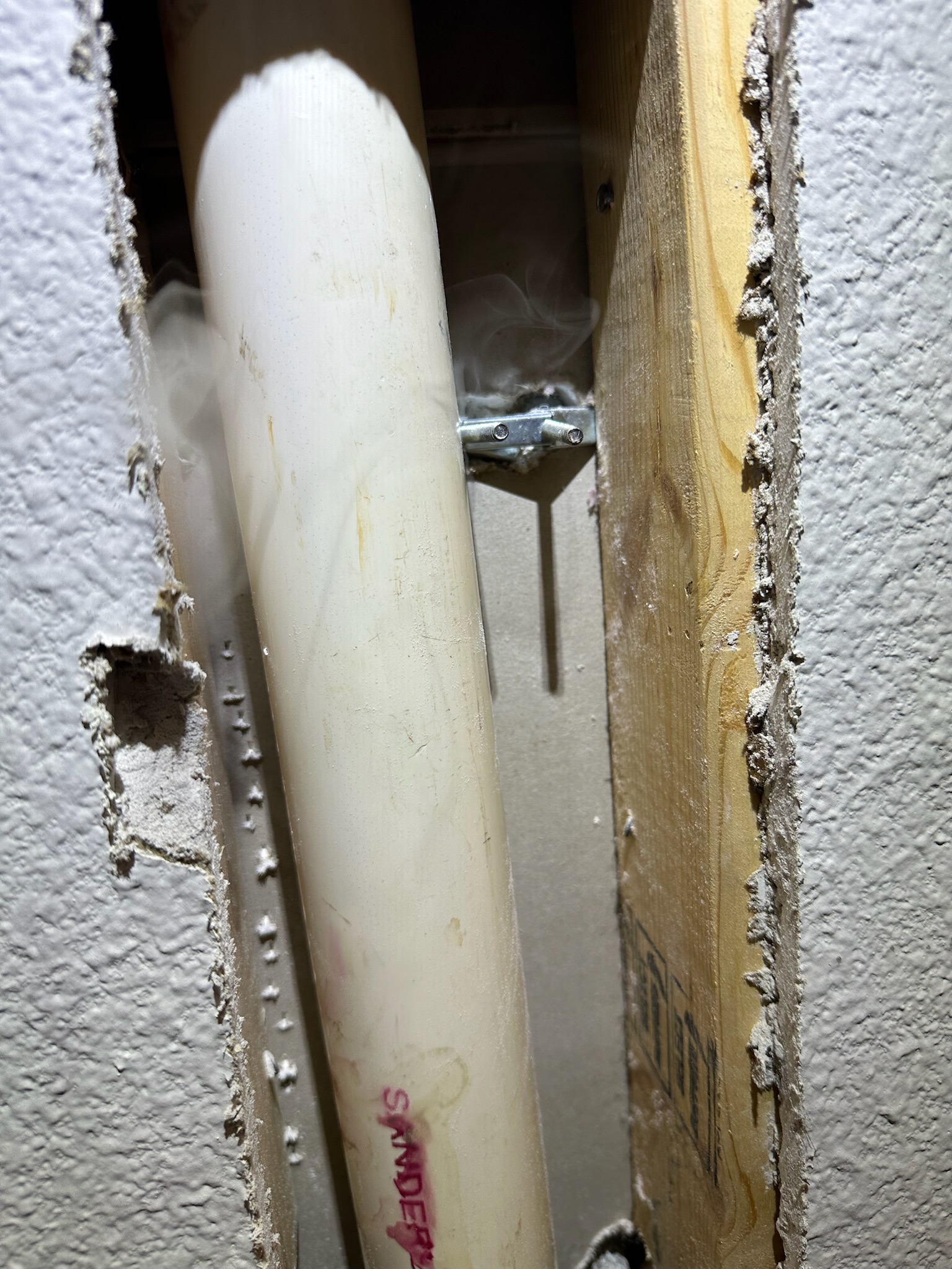 Smoke leaking from sewer pipe inside wall after screw puncture in Palm Harbor office.