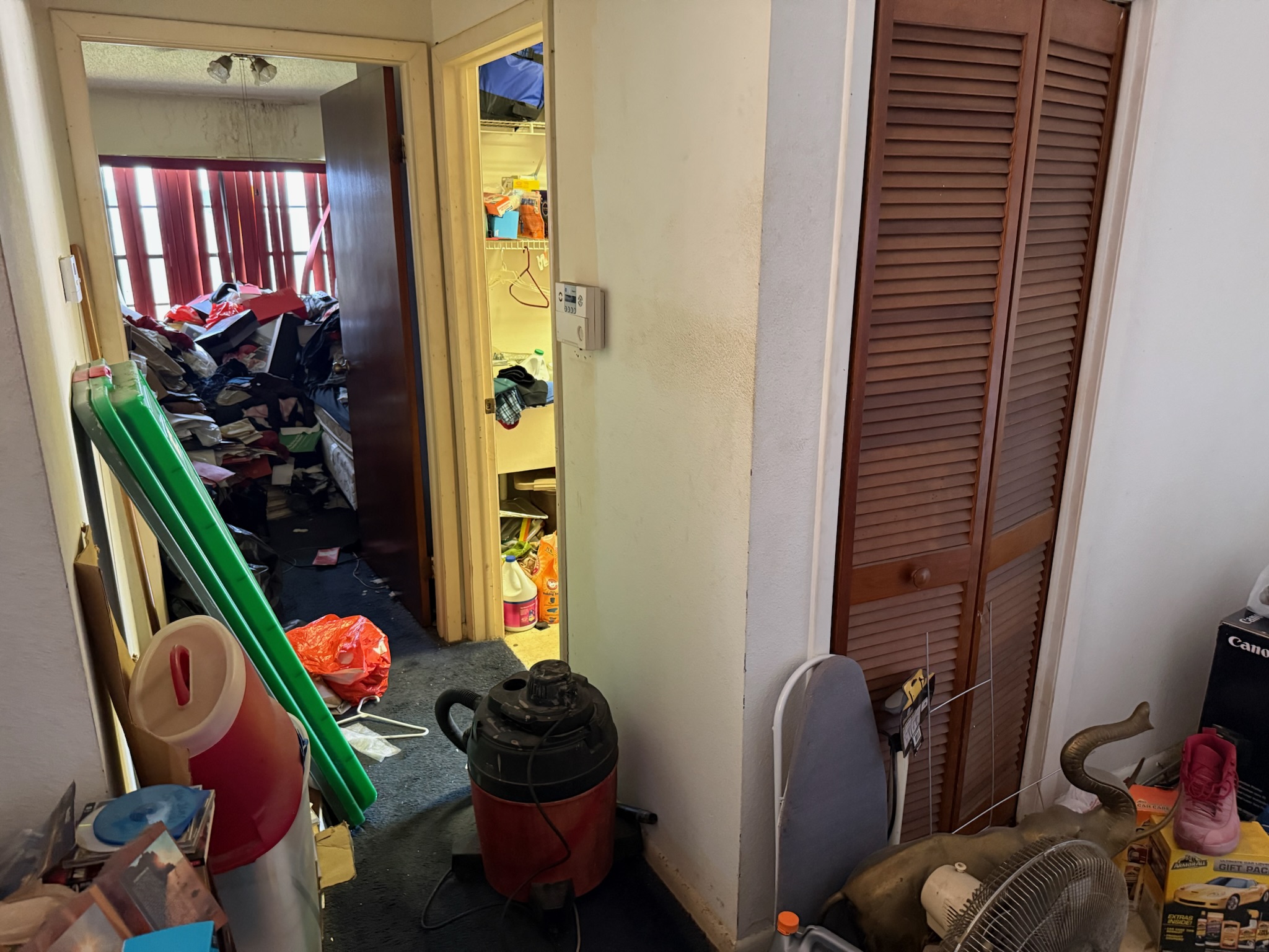 Cluttered interior of a hoarder house with household items stacked nearly six feet high