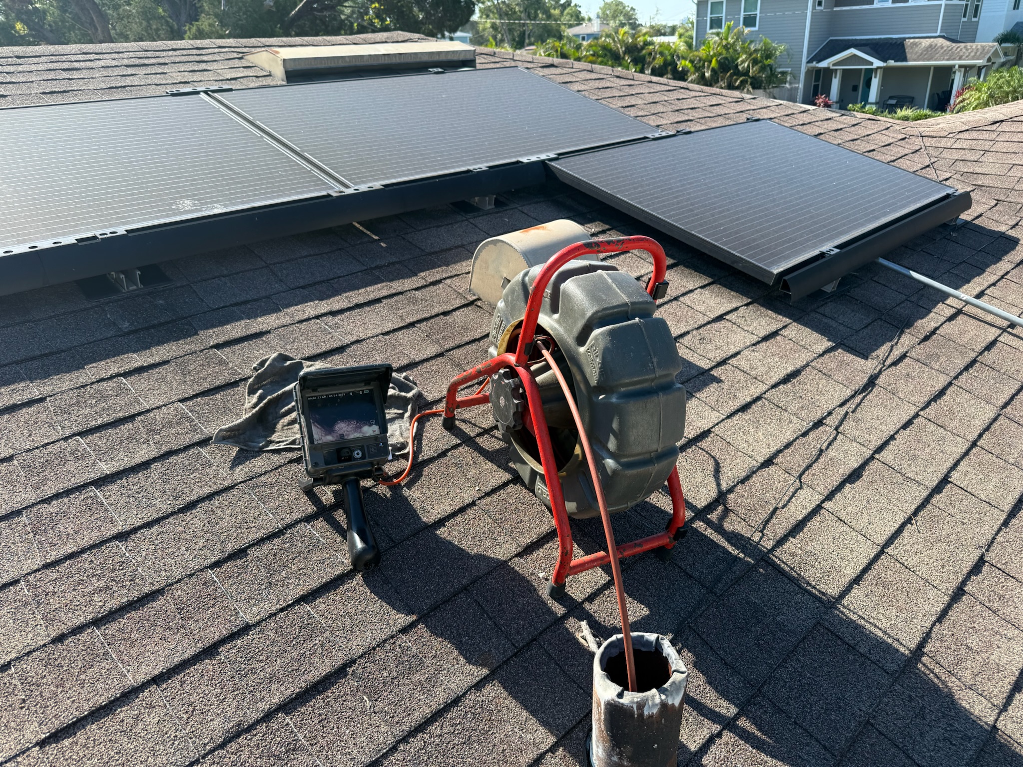 Rigid sewer inspection camera on roof inspecting Clearwater home’s sewer system via vent stack