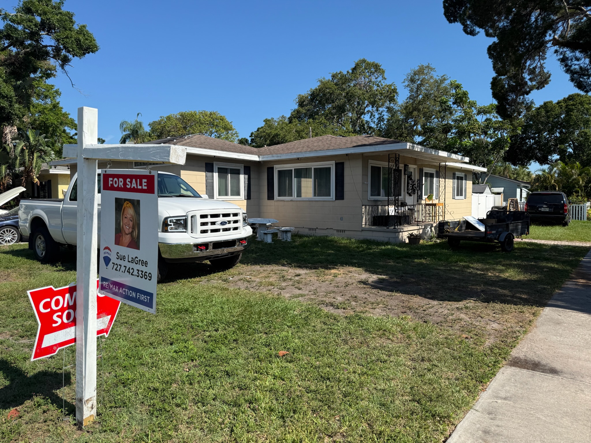 For sale sign in front of Clearwater home with white Ford truck in background during pre-purchase sewer inspection