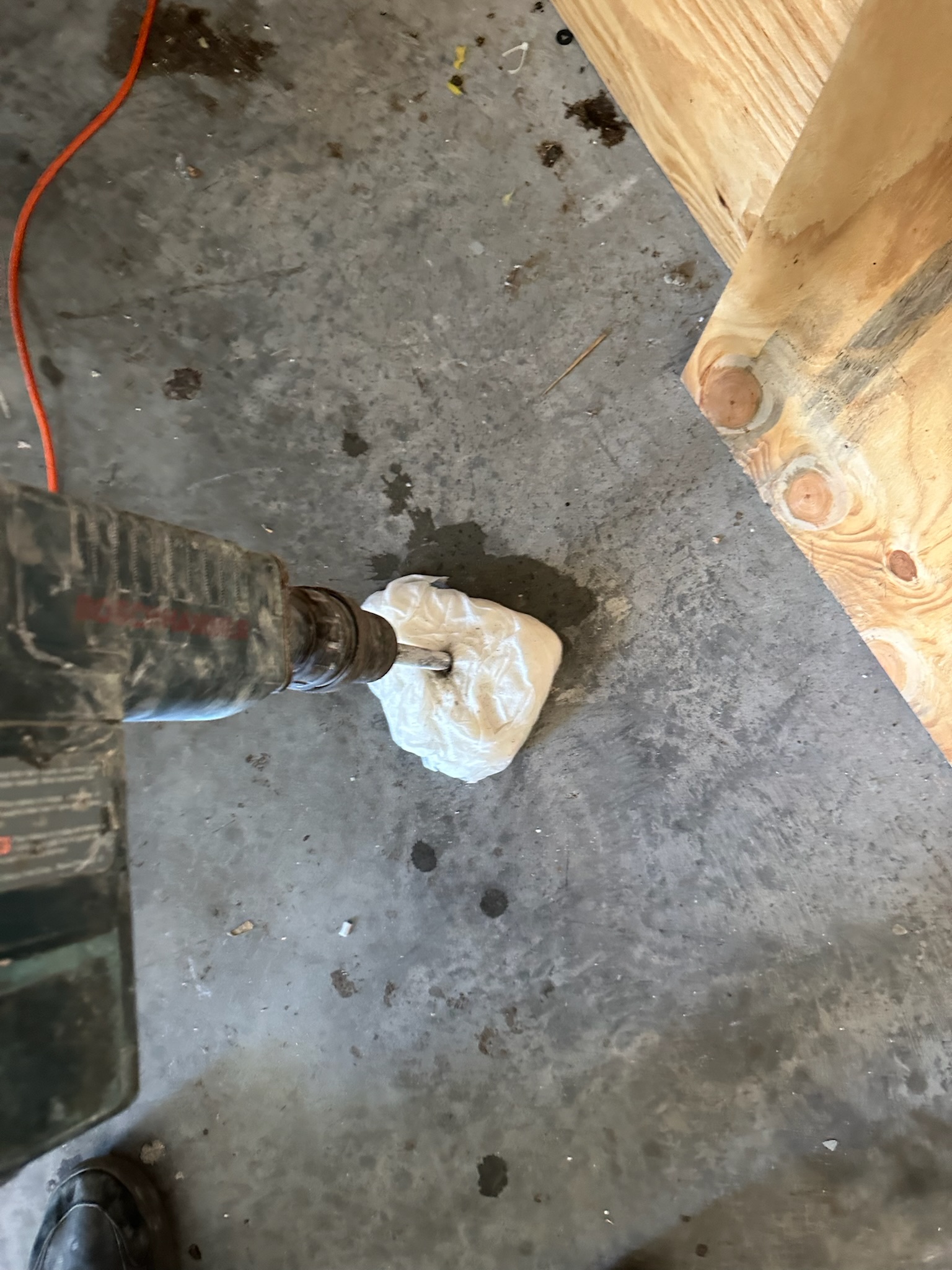 Leak detection technician jackhammering marked garage floor in Tampa
