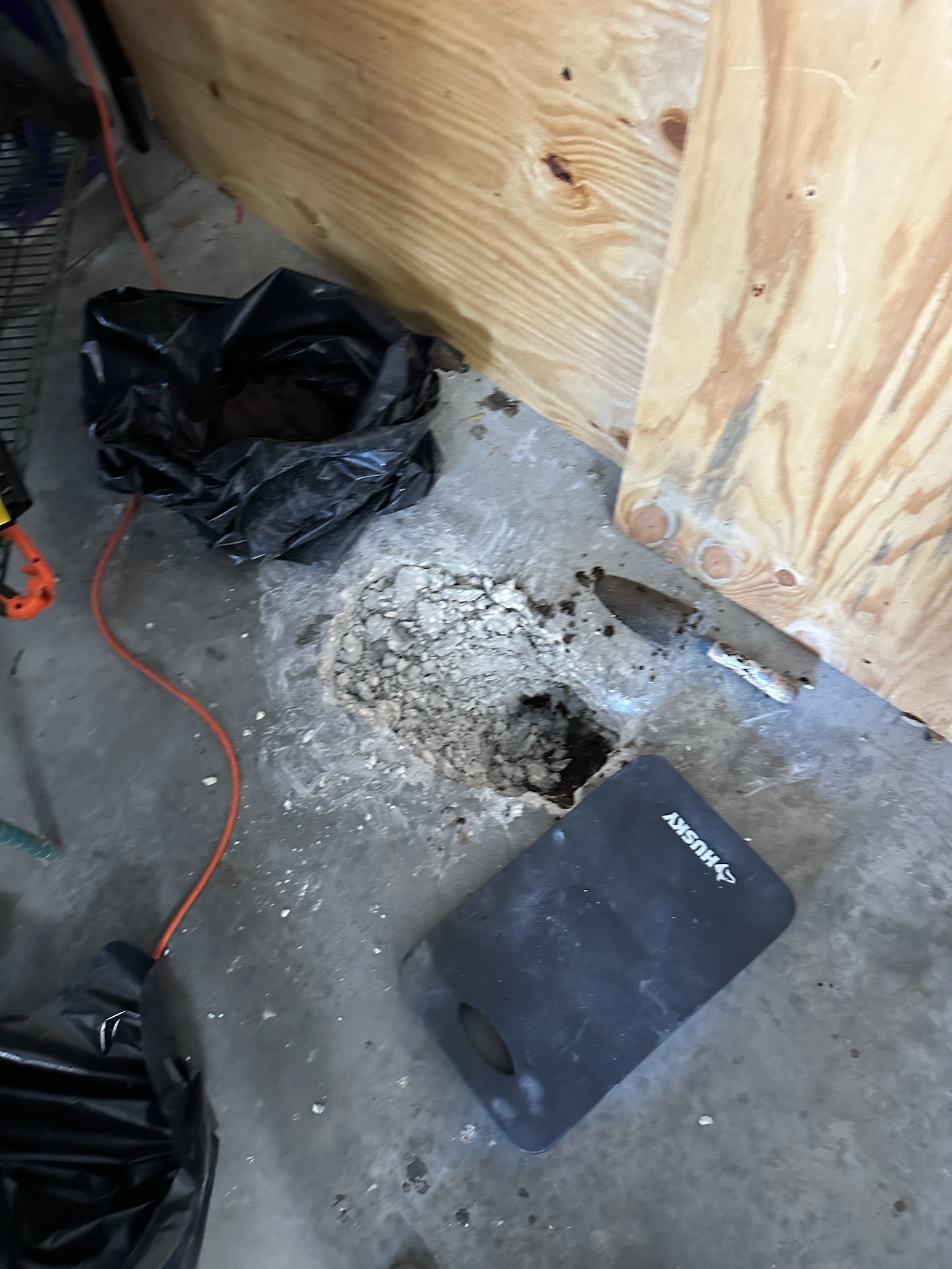 Technician clearing broken concrete during leak detection at Tampa home