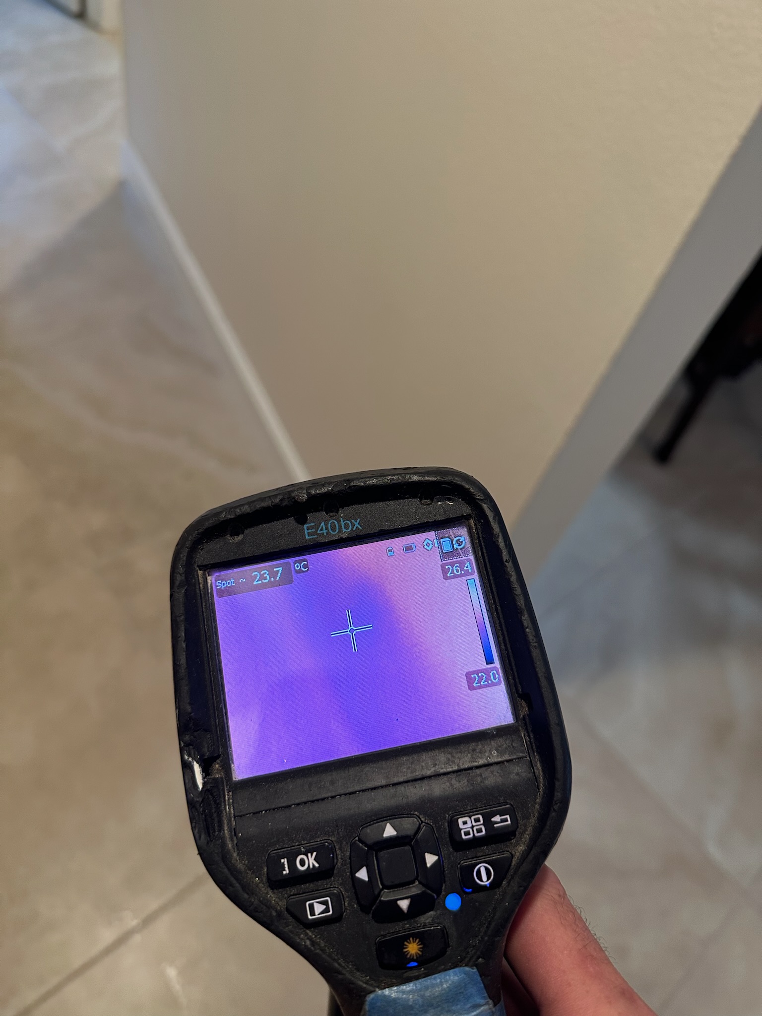 FLIR infrared image showing moisture several inches up a wall behind a slightly lifted baseboard in a Westchase home.