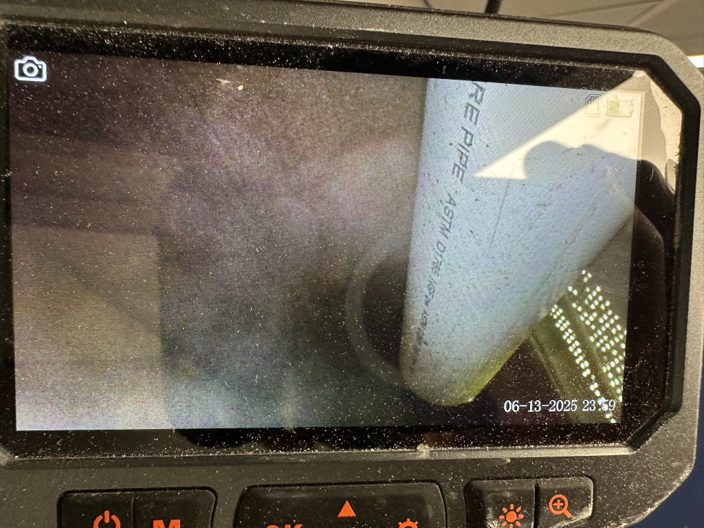 Broken sewer pipe discovered inside wall with smoke leaking from the damaged PVC connection