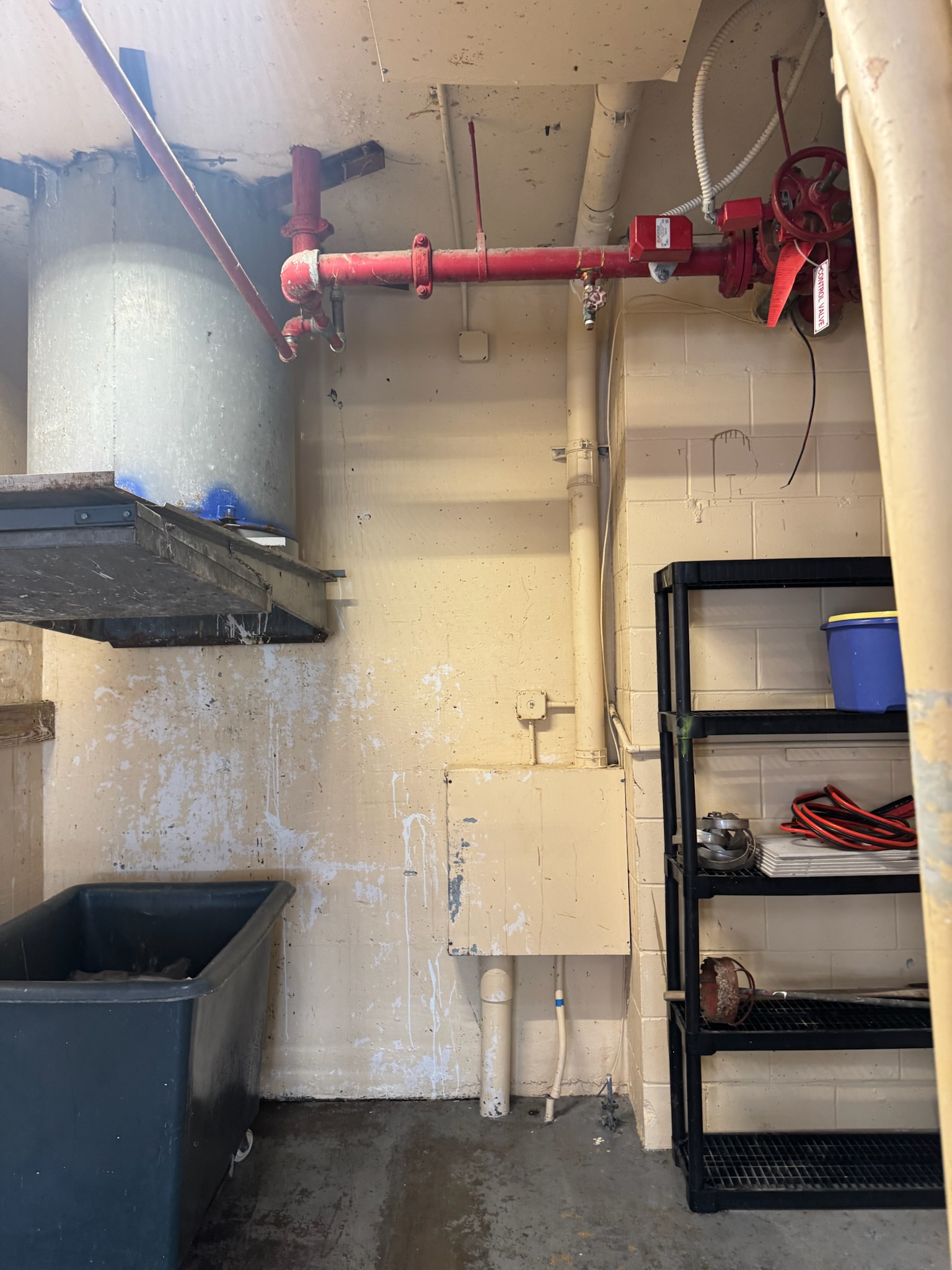 Fire suppression lines running around a trash chute in a Clearwater Beach condo near a suspected water leak