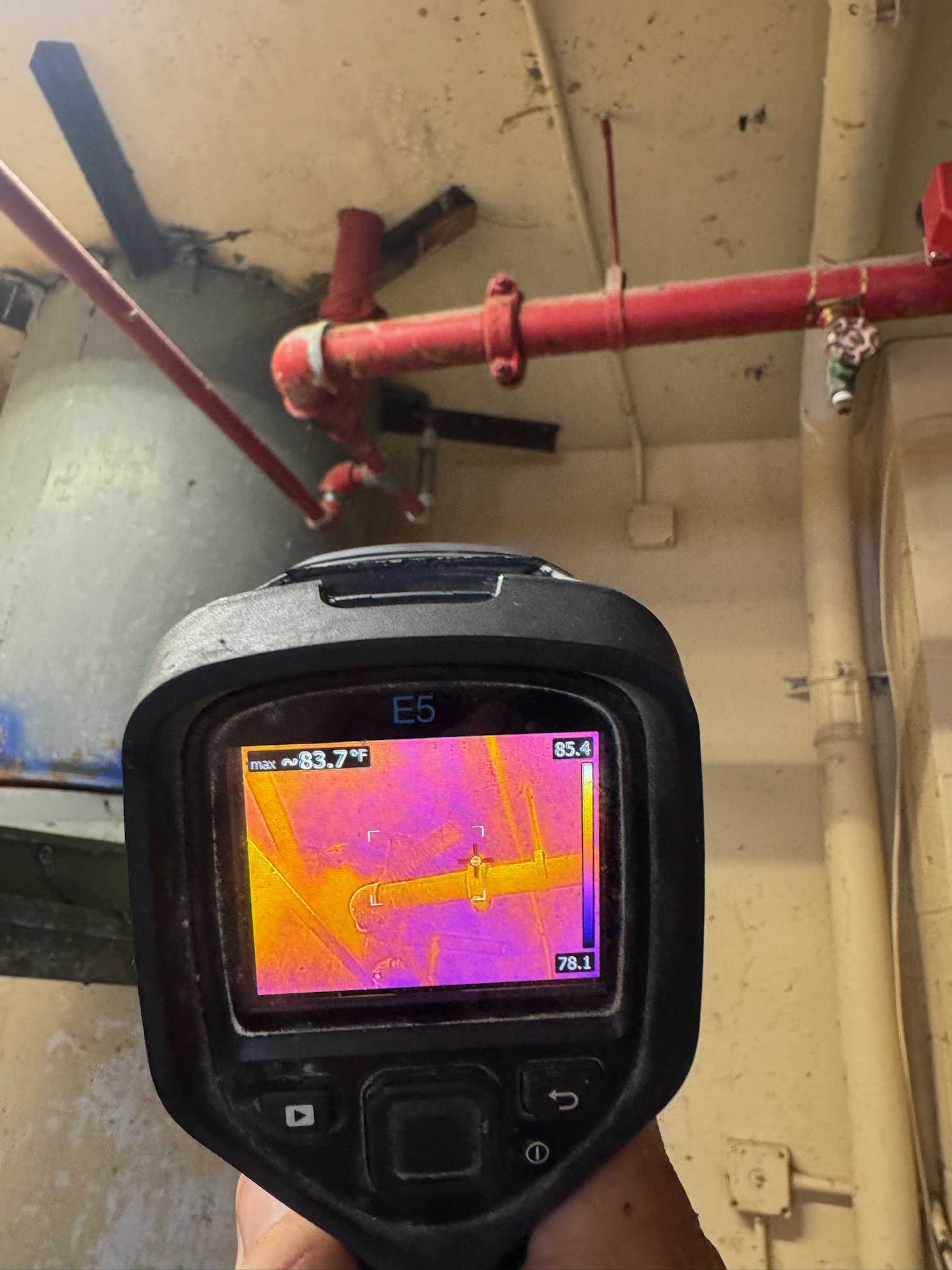 Jeremy using a FLIR infrared camera to inspect moisture near fire lines in a Clearwater Beach condo ceiling