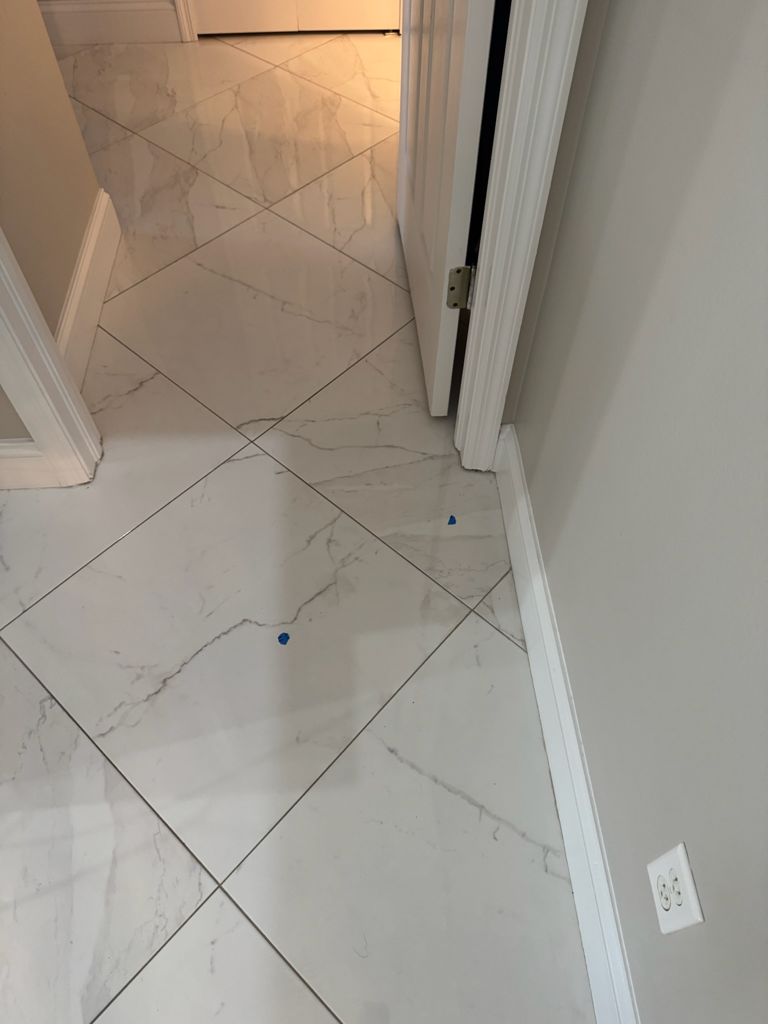 Tile hallway in Clearwater home with blue tape marking pipe location for slab leak detection