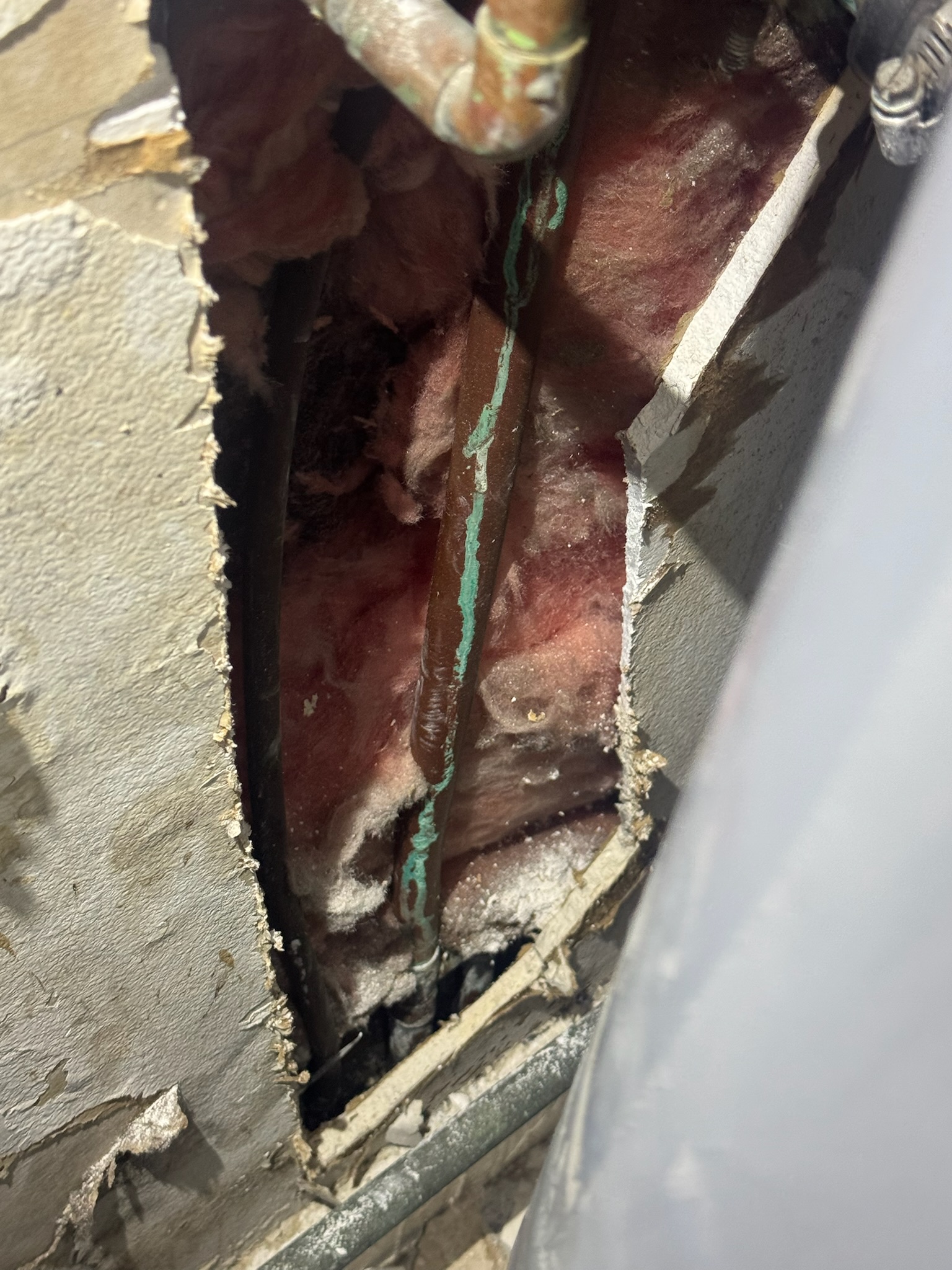 Wall opened behind water heater revealing leaking ¾” copper pipe in Clearwater home