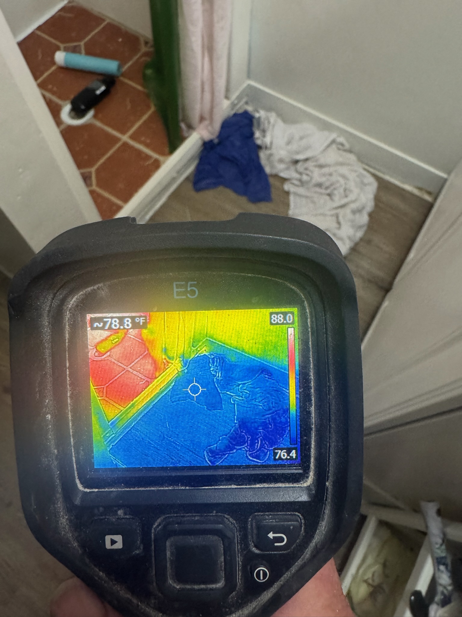 Thermal scan around the shower Infrared camera scan near stand-up shower with towels on bathroom floor