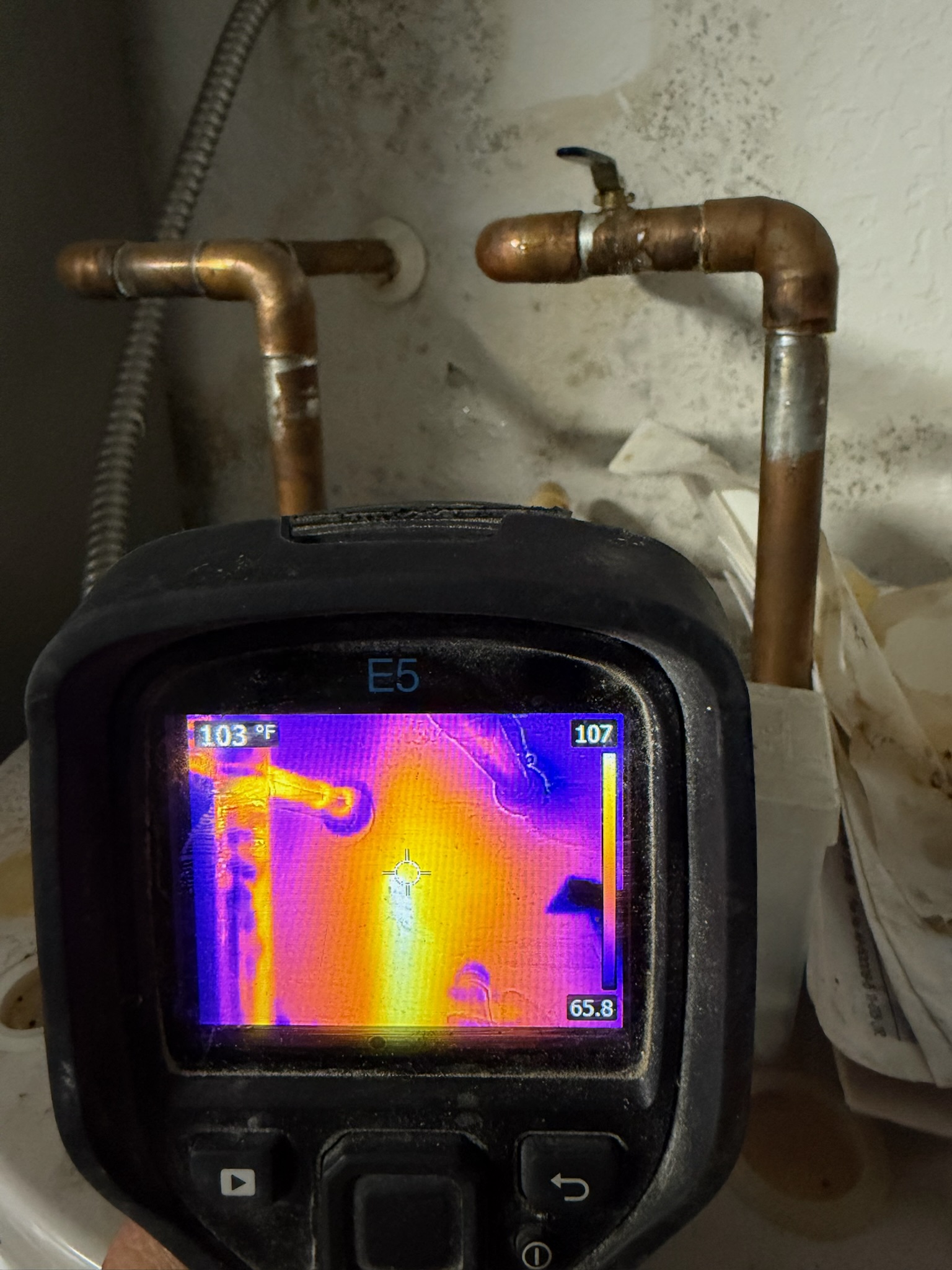 Infrared leak detection of water heater pipes showing a hidden pipe leak through the wall