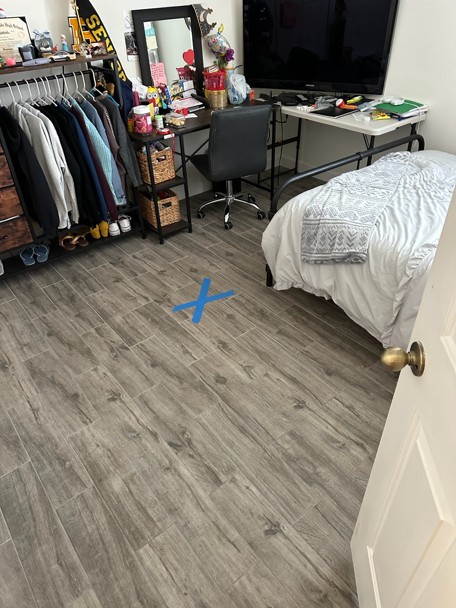 Blue X marks exact slab leak location on floor during high water bill investigation in St. Petersburg home