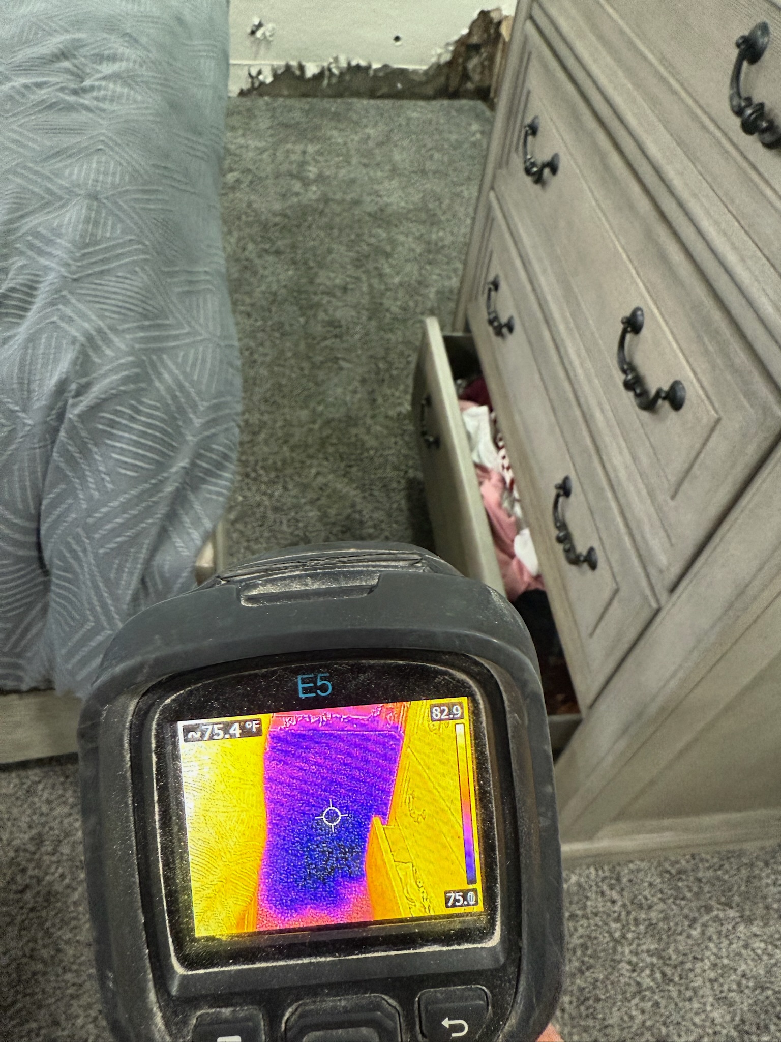 I Find Leaks technician using a FLIR infrared camera to track moisture in bedroom carpet during a St. Petersburg water leak inspection.