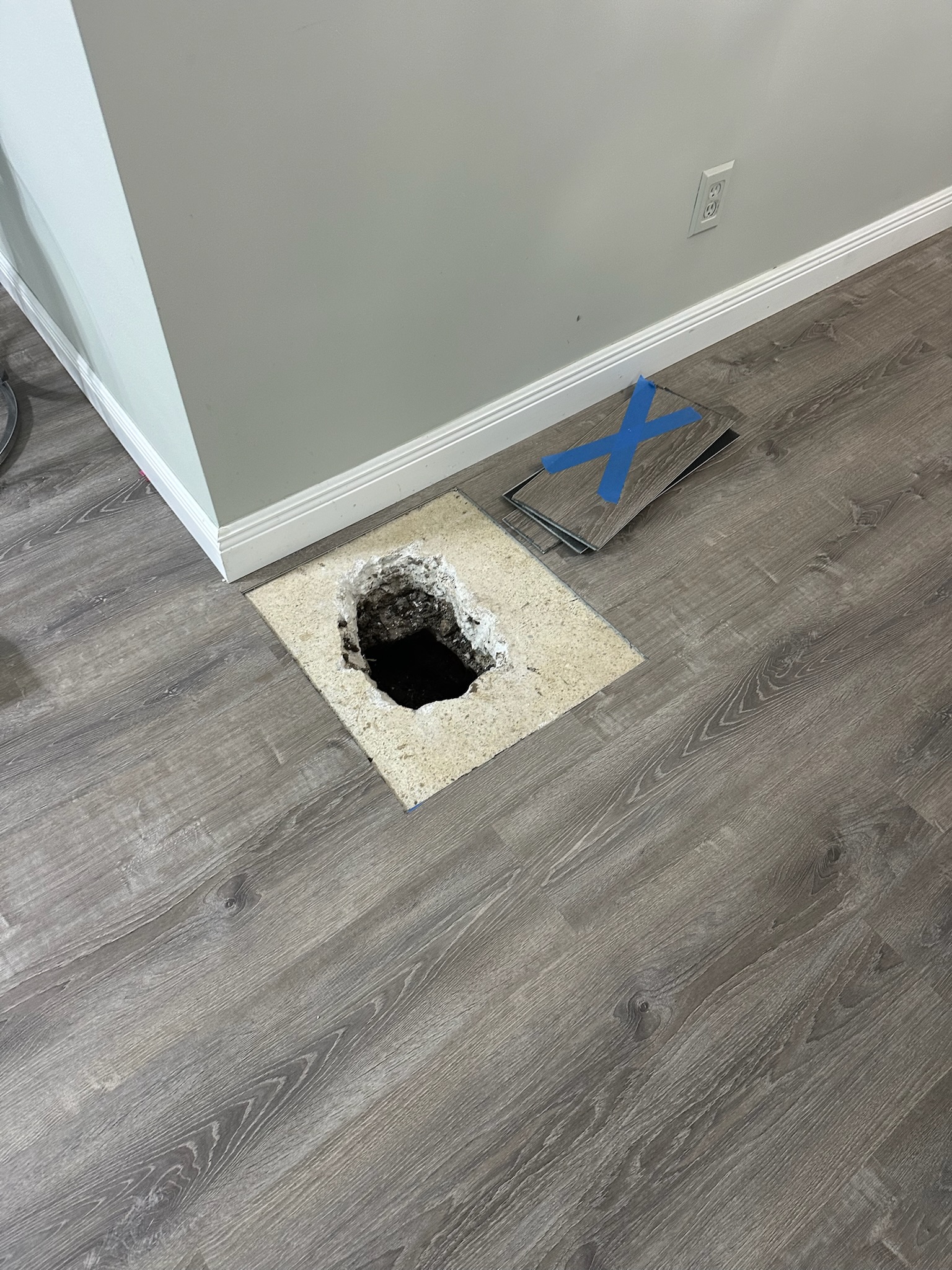 Small access hole in terrazzo floor after slab leak location was pinpointed in Clearwater home