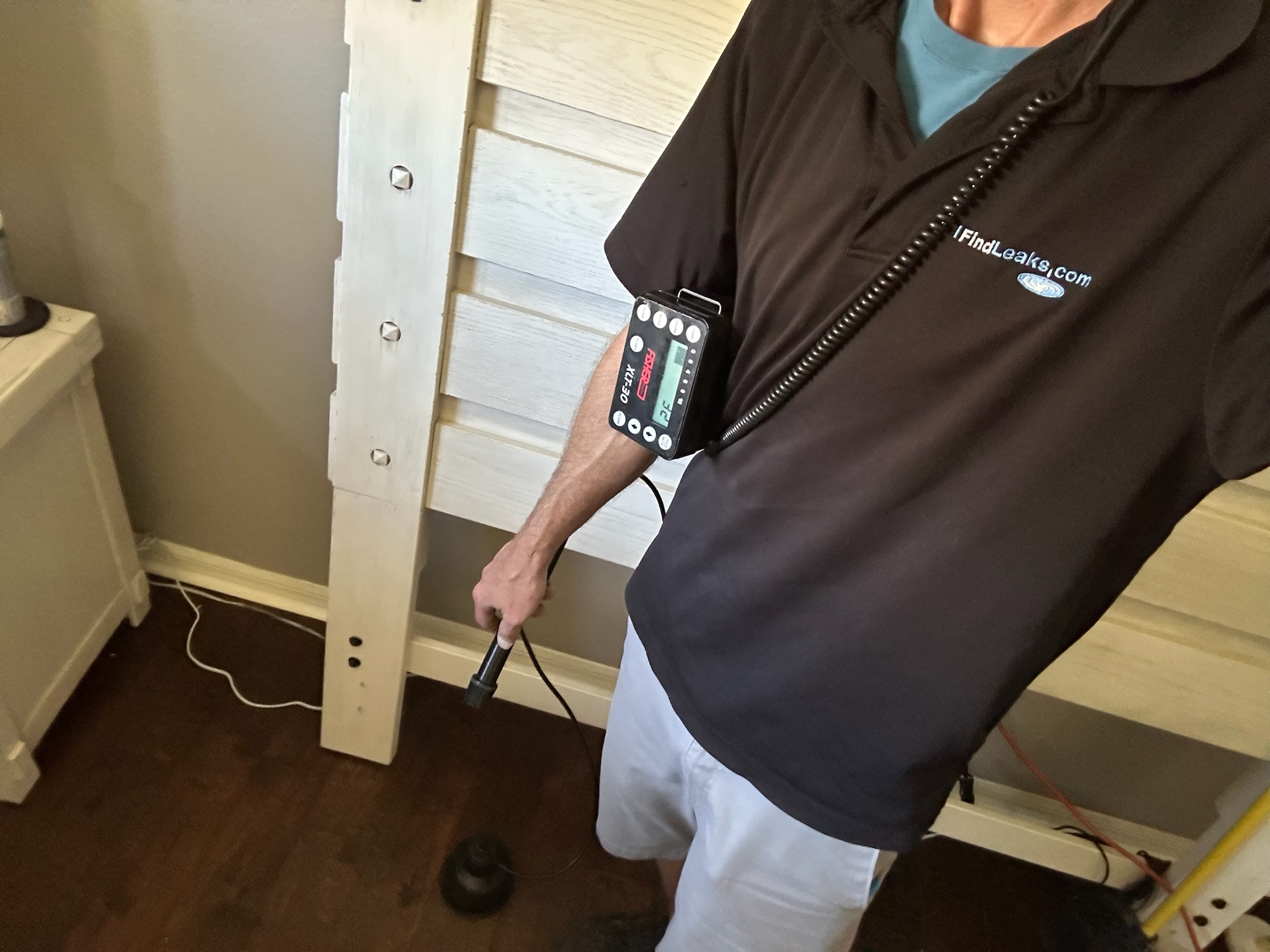 Oldsmar Water Leak Detection - Fisher Acoustic Listening Equipment Tyler using Fisher acoustic leak detection equipment on a bedroom wood floor to verify a suspected leak location in Oldsmar.