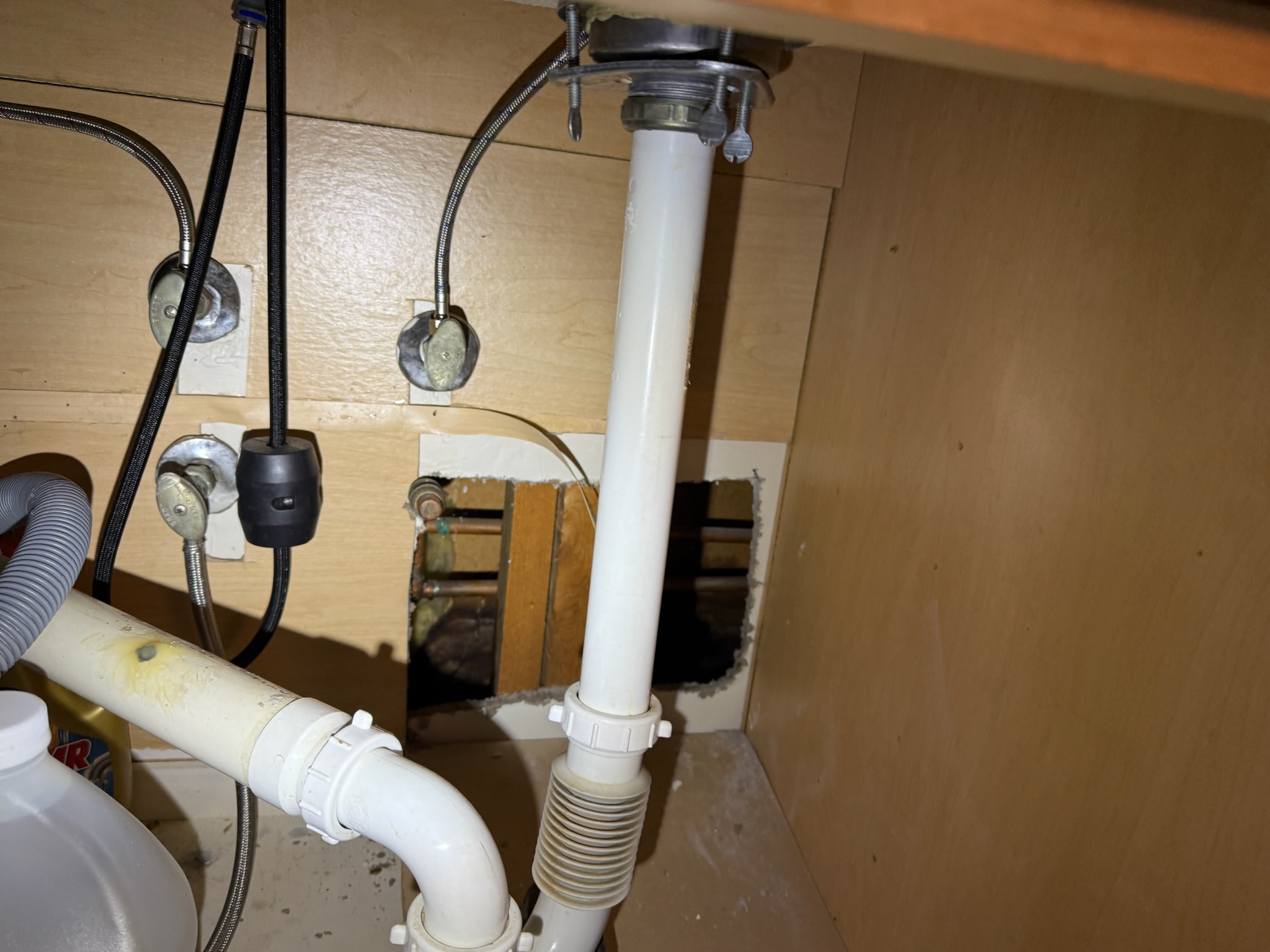 Palm Harbor water leak detection photo showing a targeted cabinet opening under a kitchen sink after ultrasonic listening located the leak area.