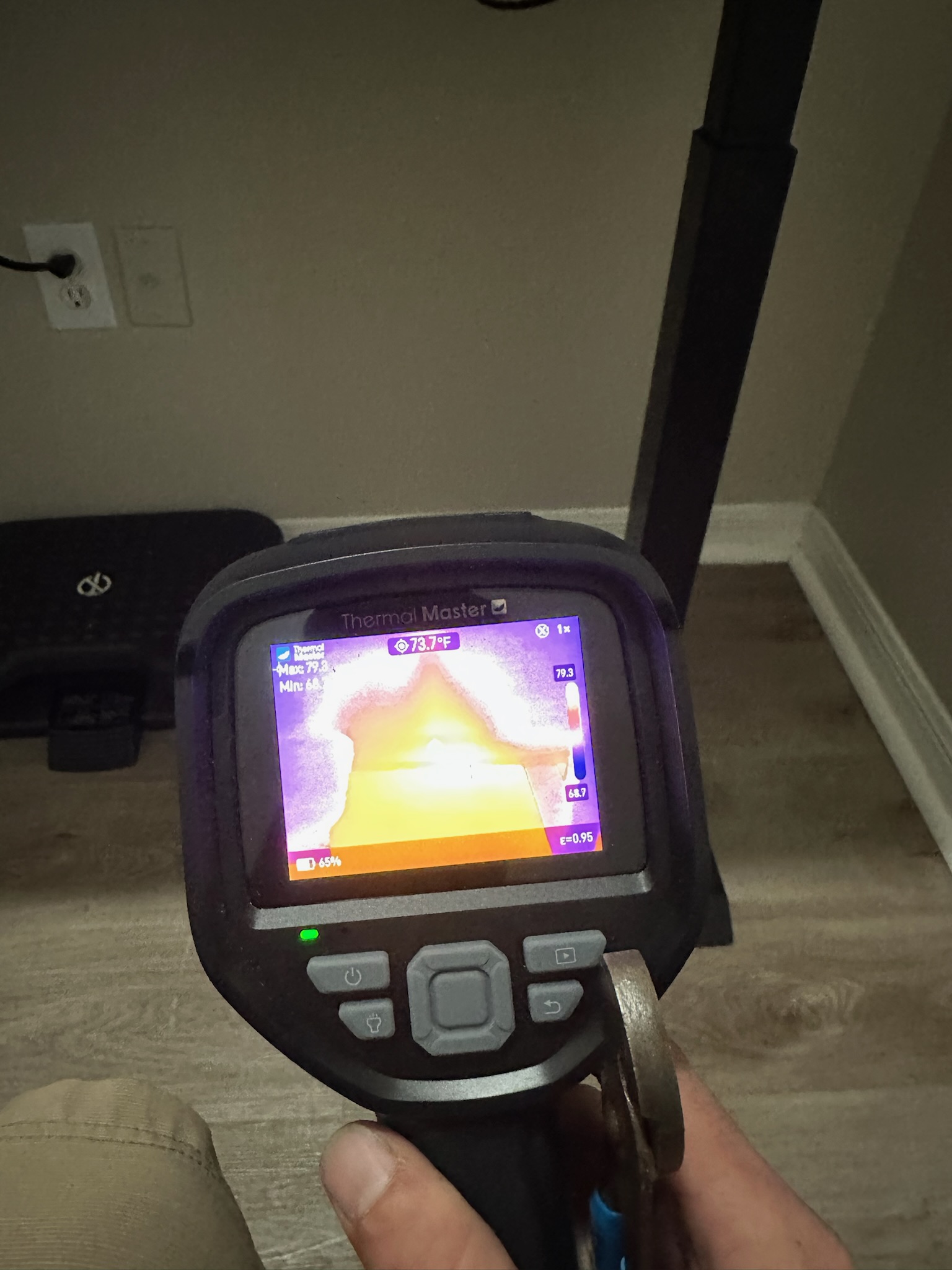 Tyler scans opposite side of wall with infrared camera during St. Petersburg leak detection inspection