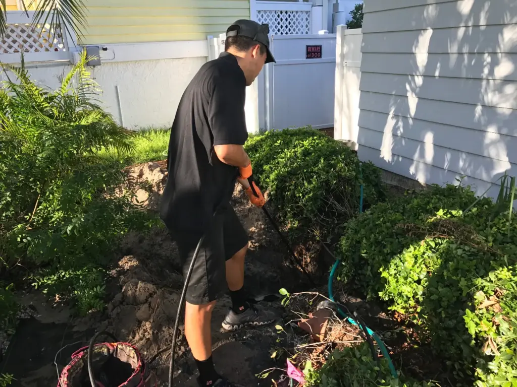 I Find Leaks technician listening to a yard supply line with an ultrasonic probe