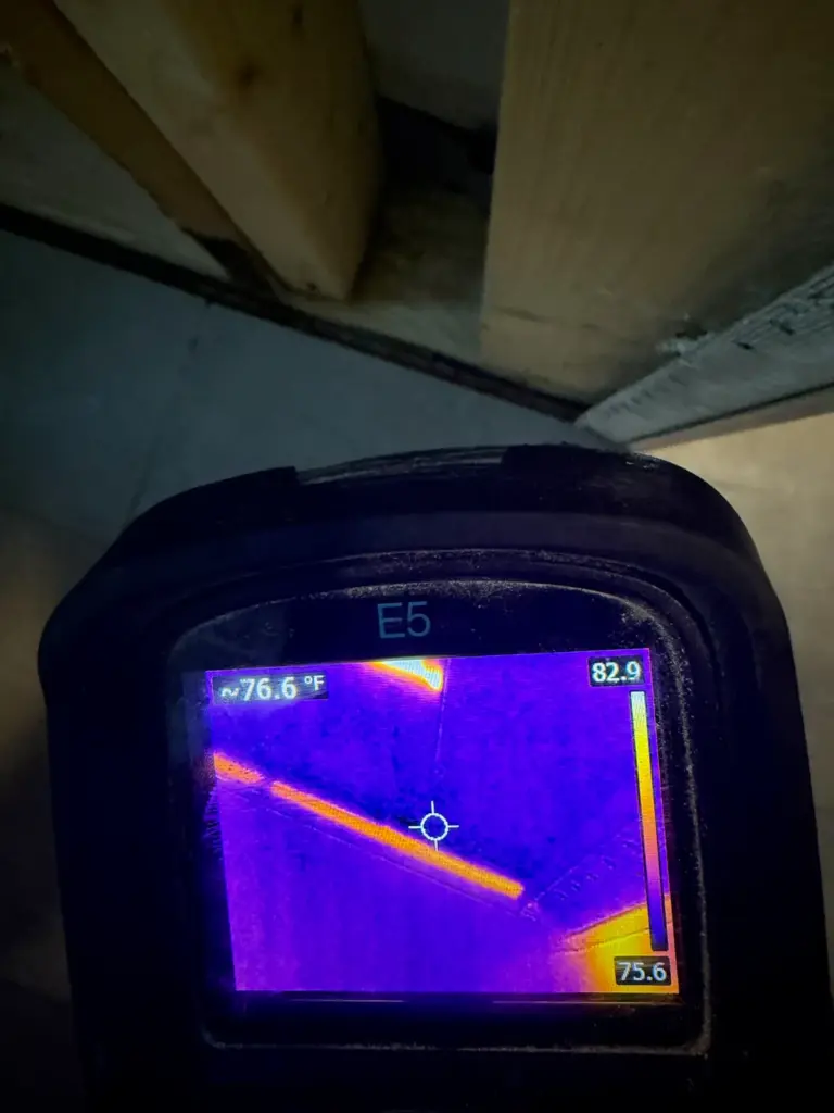 Close-up of a thermal camera screen showing one warm diagonal line against a purple background.